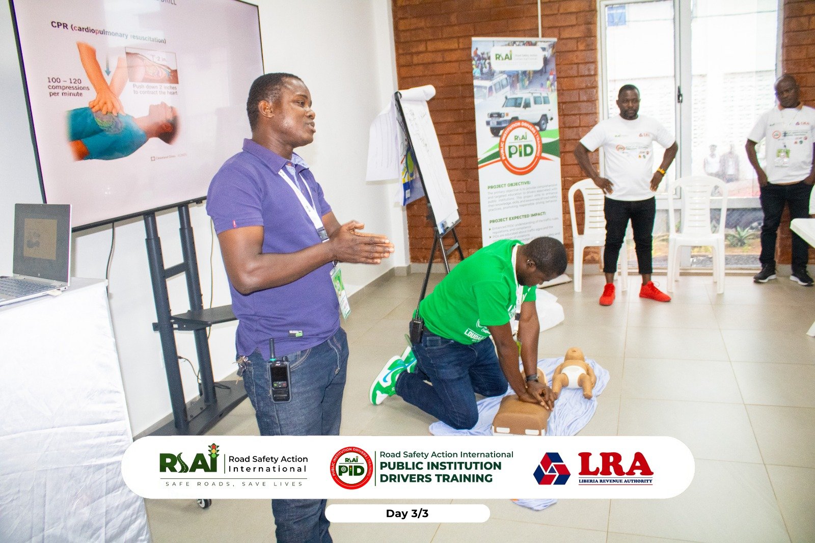 A facilitator explains CPR while a participant practises chest compressions on a training manikin