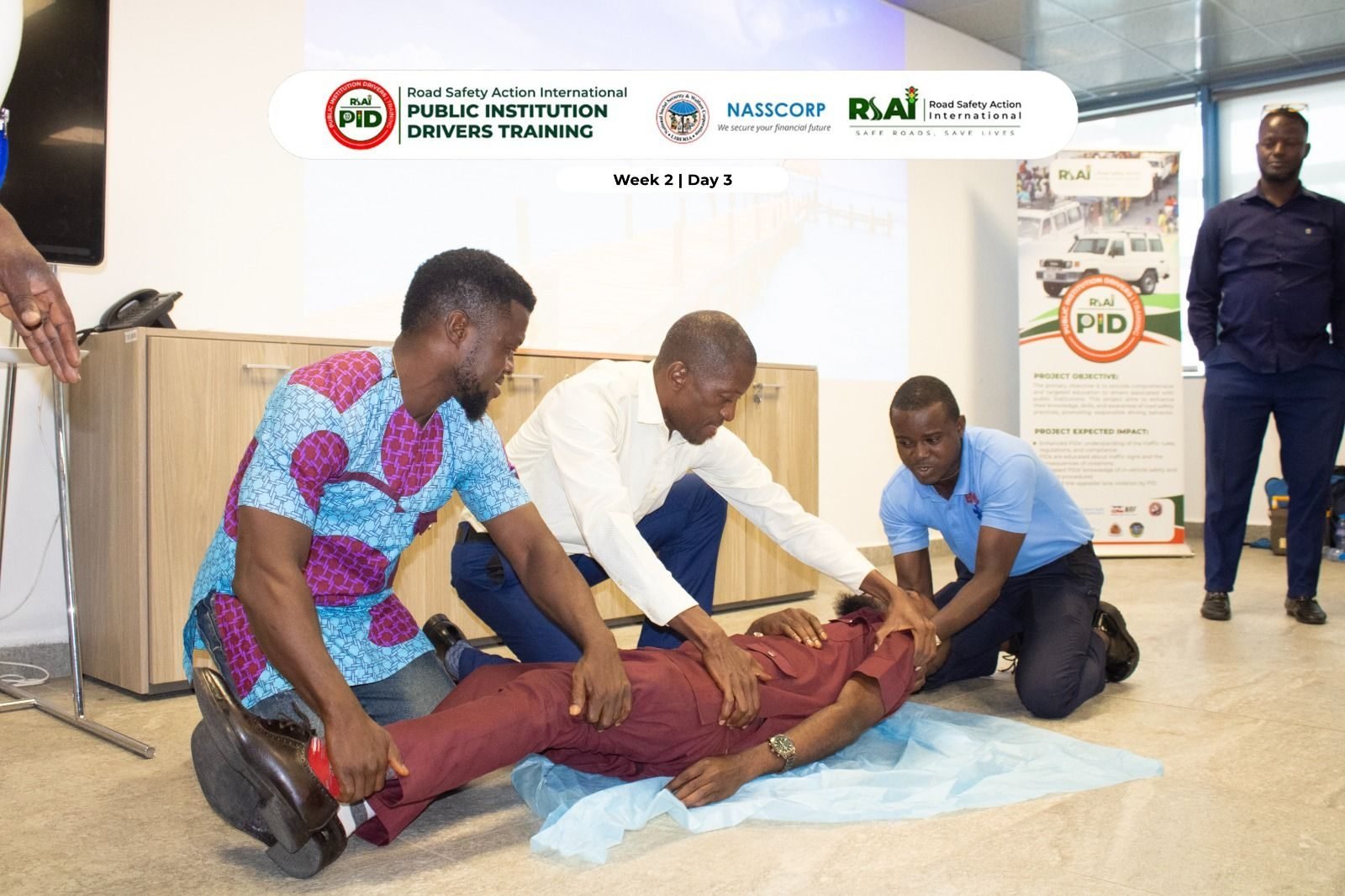 Participants practise stabilising a casualty lying on the floor