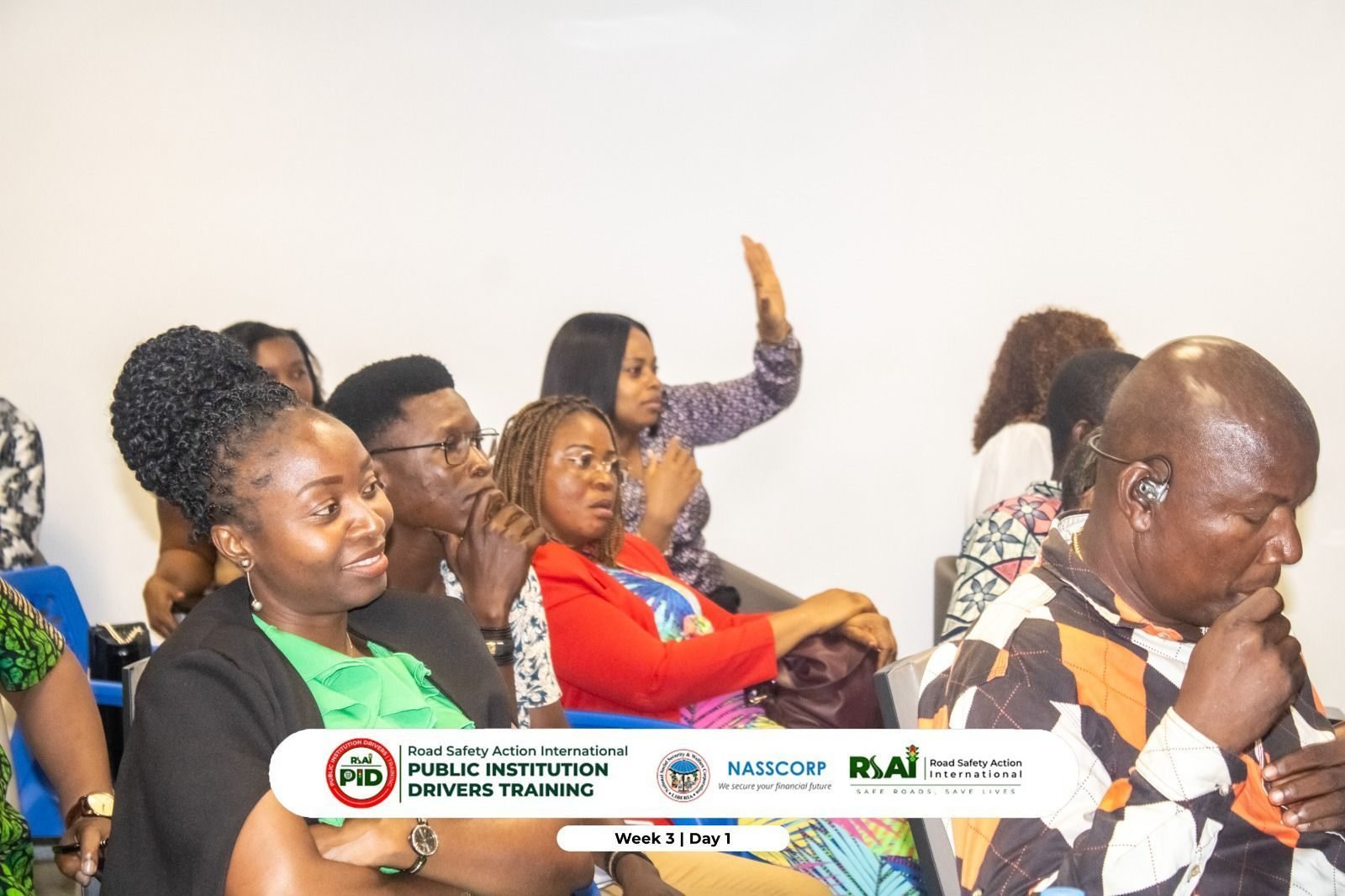 A participant raises her hand to ask a question